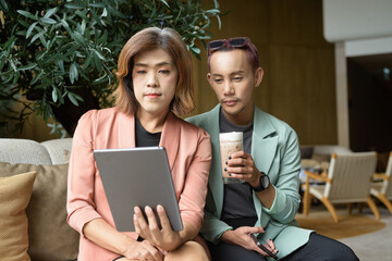 Transgender and non-binary coworkers working remotely in cafe