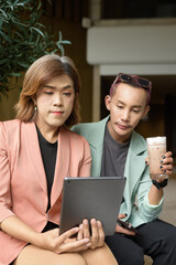 Transgender and non-binary coworkers working remotely in cafe
