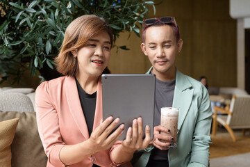 Transgender and non-binary coworkers working remotely in cafe