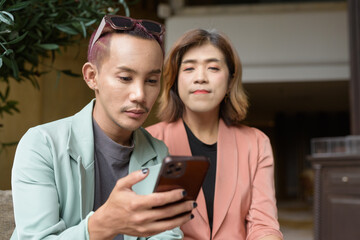 Transgender and non-binary coworkers working remotely in cafe