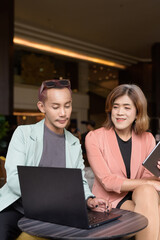 Transgender and non-binary coworkers working remotely in cafe