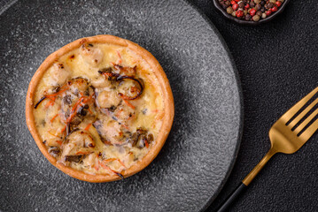 Pie or quiche, a sour tart with chicken and mushrooms, spices and herbs. Round quiche with chicken