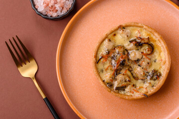 Pie or quiche, a sour tart with chicken and mushrooms, spices and herbs. Round quiche with chicken