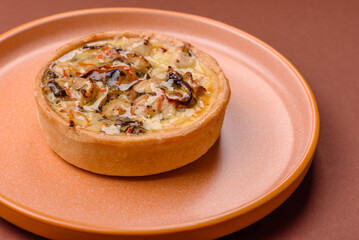 Pie or quiche, a sour tart with chicken and mushrooms, spices and herbs. Round quiche with chicken