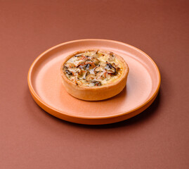 Pie or quiche, a sour tart with chicken and mushrooms, spices and herbs. Round quiche with chicken