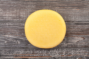wheel of cheese on wood background top view