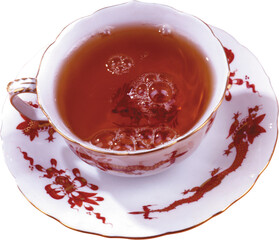 Close up overhead view of a delicate porcelain teacup filled with hot amber tea and frothy bubbles...
