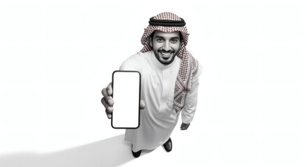 Saudi man in traditional attire holding blank smartphone, white background, studio shot.