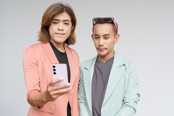 Transgender and non-binary coworkers against plain background