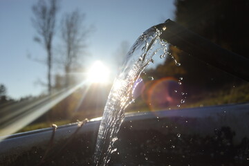 Stream of water is flowing from a pipe into a small pool