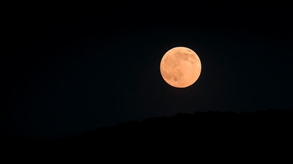 Full Moon Rising Over a Hill with Glowing Orange Hue and Starry Night Sky