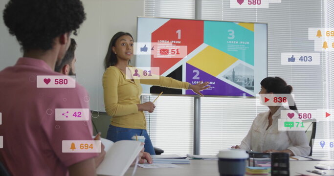 Pointing businesswoman presenting infographic slides on screen in conference room, with notebooks