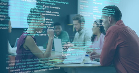 Software development team reviewing code in office, with laptops, notebooks and projected code