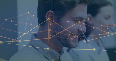 Customer service agent wearing gray shirt and headset analyzing network graph overlay at office