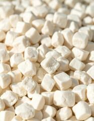 A close-up of Aaruul (dried curd/cheese), small, hard, white pieces, a traditional nomadic snack.