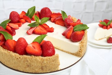 Delicious cheesecake with strawberries and mint on table, closeup