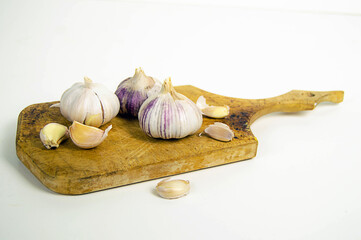 fresh garlic on a vintage board on a light plain background