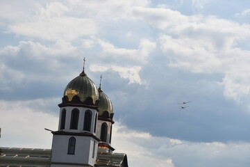 A light aerobatic aircraft performs a solo maneuver in front of cumulus clouds during a summer...