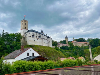 View of the Rozmberk nad Vltavou castle. A flag is flying on the tower. Gray sky