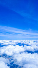 Peaceful airplane window view showing calm clouds and endless blue sky