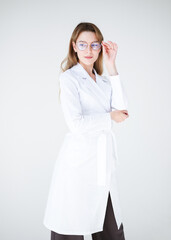 Female doctor in white coat and glasses looking forward with serious expression. Confident and...