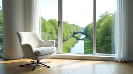 A modern white armchair by the panoramic window overlooking the river, the green park and the city buildings. A bright room and the morning sun create a cozy atmosphere.