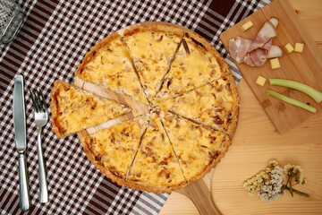 Savory quiche with ham and cheese slices on wooden serving board