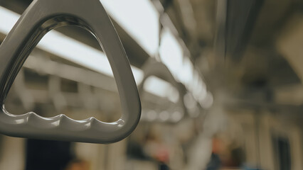 Close-up detail of the gray hanging handrail inside the train carriage