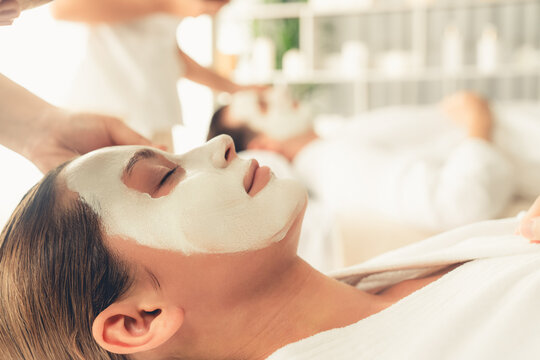 Serene ambiance of spa salon, couple indulges in rejuvenating with luxurious face cream massage with modern daylight. Facial skin treatment and beauty care concept. Quiescent