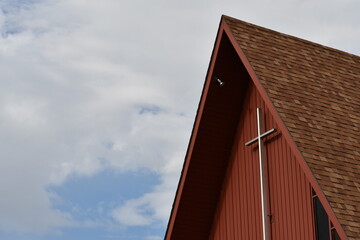 High slope roofed church. Red paint, wooden construction.