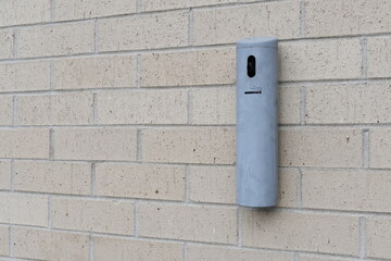 Cigarette disposal unit mounted on wall. Integrated ashtray.