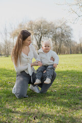 A portrait of a happy, loving mother hugging her little child outside.