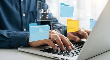 A person is managing digital files and folders on a laptop, showcasing data management and organization in a modern technological environment