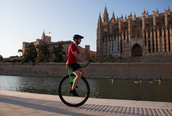 Young unicyclist practising with his unicycle in the Parc de la Mar, in Palma (Mallorca), next to the Gothic cathedral of the Balearic capital. © Jaume Rosselló