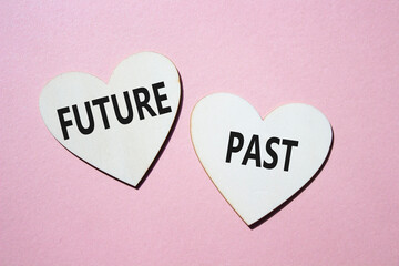 Future or Past symbol. Concept word Future or Past on wooden hearts. Beautiful pink background....