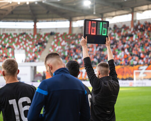 
Team manager man shows players substitution during football match.