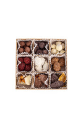 Natural sweets in chocolate without sugar. Dried fruits and berries in chocolate in box on white background. Vertical