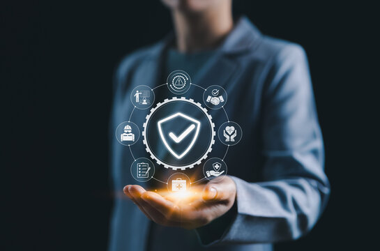 Work safety and compliance management concept. A person holds a shield check surrounded by safety, compliance, and risk assessment symbols, representing occupational health and workplace regulations.