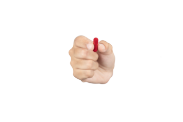 Hand holding a red pill capsule. Concept of healthcare, choice, medical treatment, or drug addiction. Taking daily vitamins or prescription medication. isolated on white background with clipping path.