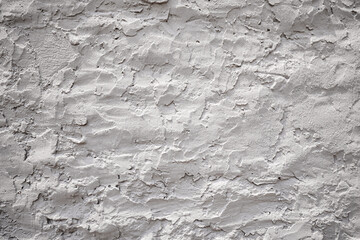 Close up view of a textured concrete wall, showcasing its rough and uneven surface in shades of...