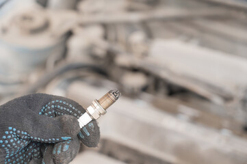 Caucasian man changing spark plugs in car. 