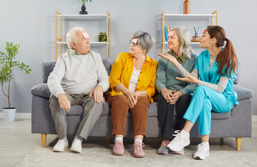 Happy nurse playing with group of a senior people in the Who I Am game at a nursing home. Fun and...