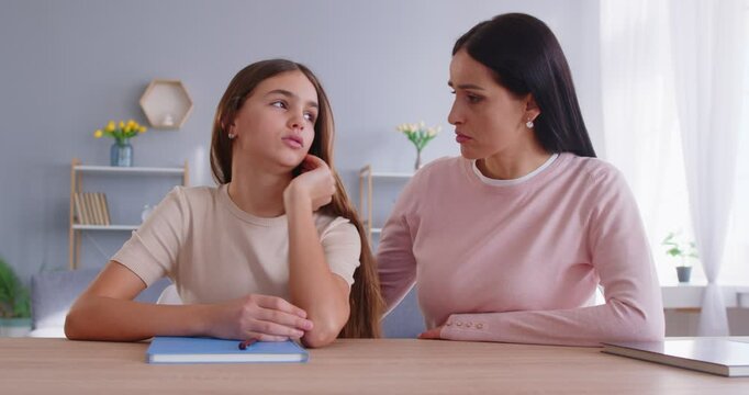 Supportive mother helps her teenage daughter with doing homework supports and encourages for studying tries to solve difficult life problem. Family relationships and disagreement concept