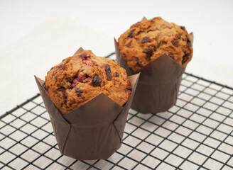 Delicious Valrhona Raspberry Chocolate Muffins boasting a golden brown top and visible fruit and...