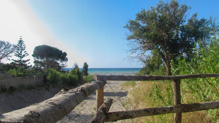 Wooden fence overlooking a covered stream leading to the Mediterranean Sea along the Sicilian coast...
