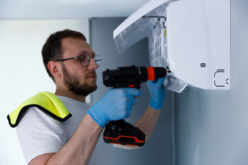 Professional technician, wearing gloves and glasses, carefully installing or repairing a...
