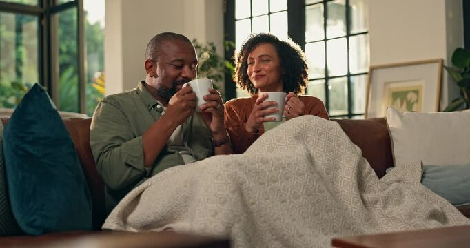 Mature African couple, coffee and toast on sofa with smile, blanket and relax with bonding in home. Man, woman and happy with drinks, celebration and love with thanks on anniversary in living room - Powered by Adobe
