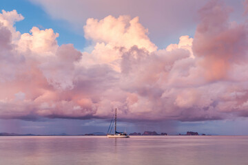 Sailboat anchored near Koh Kradan island in Andaman Sea, South Thailand. Dramatic sunset clouds. Tropical landscape.