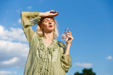 A Woman Relishing the Sunshine While Hydrating on a Warm Day: The Perfect Combination of...