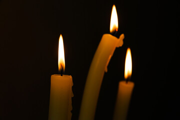 Three Illuminating Candles Dancing in the Dark, Creating a Warm and Inviting Atmosphere Perfect for Intimate Gatherings and Relaxing Moments of Tranquility and Reflection